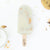 milk and cookies joypop pop with milk and chocolate on the left and two salted chocolate chip cookies on the right on a white background